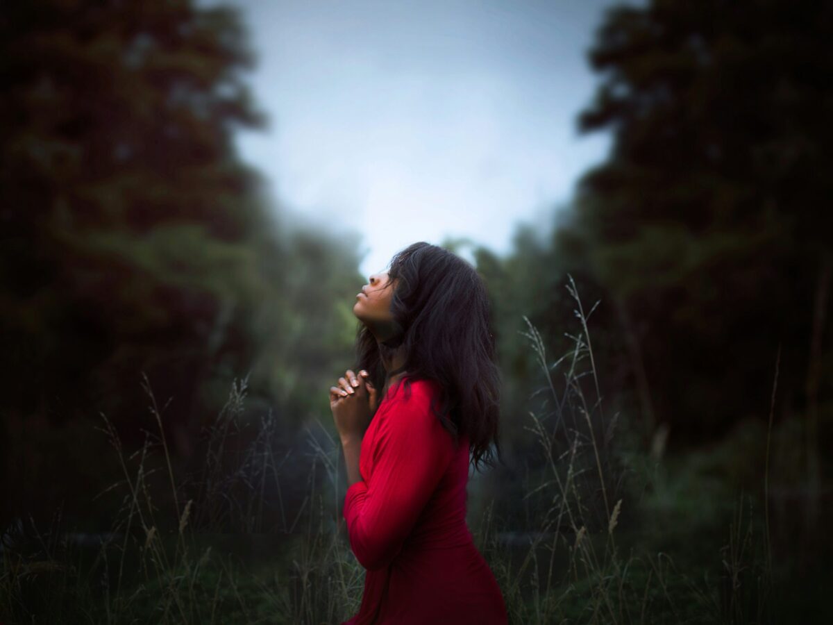 black woman lifting her head up to the sky