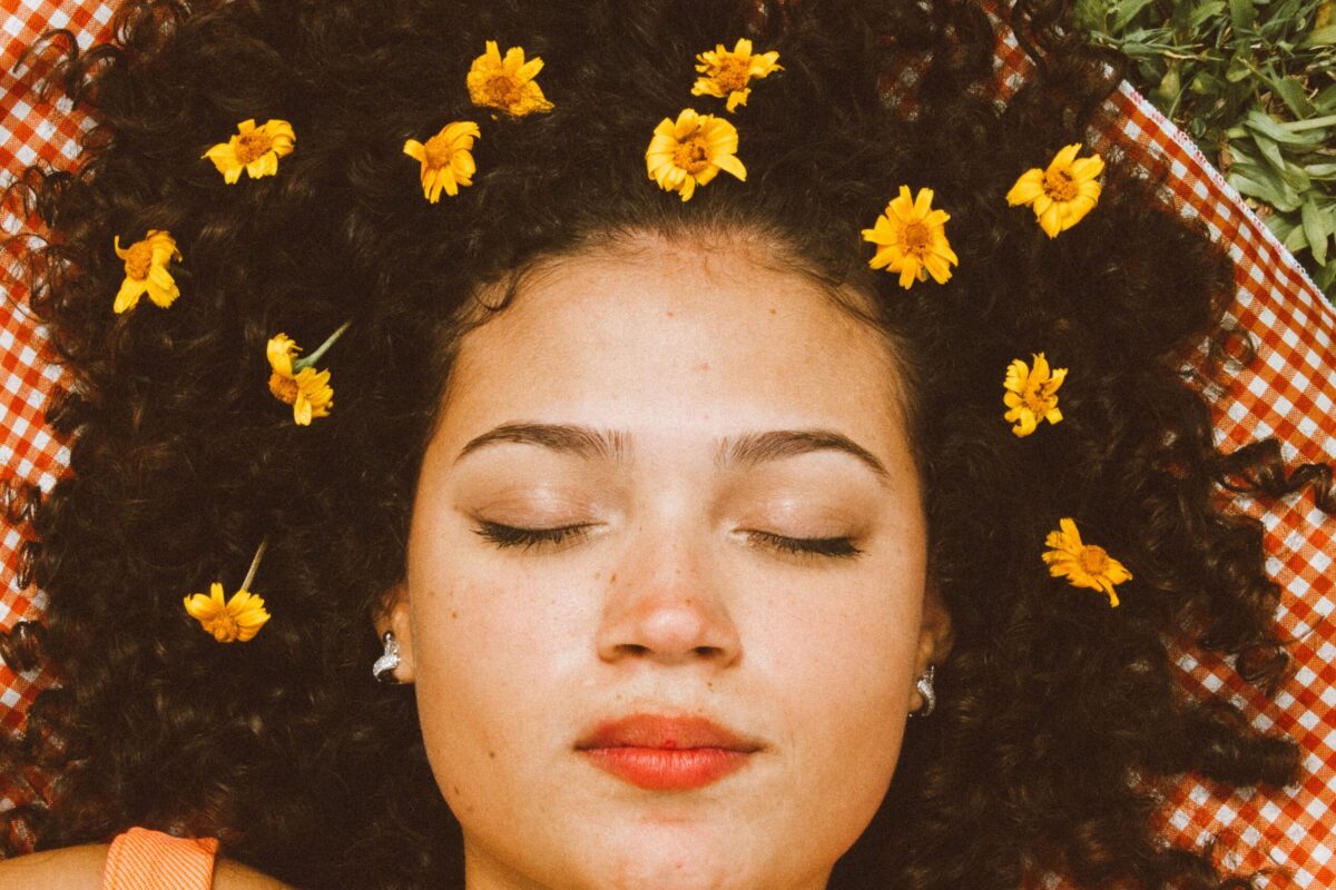 woman with closed eyes and sunflowers in hair