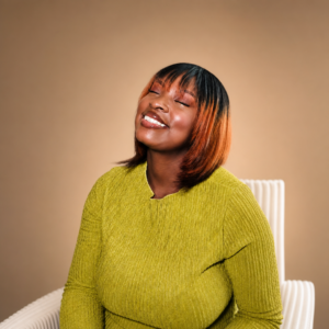 smiling woman sitting in chair wearing green 