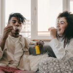man blowing bubbles with smiling woman
