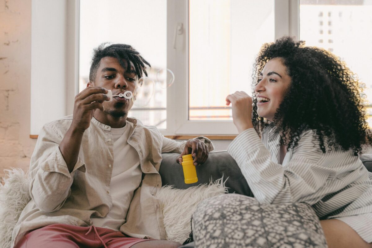 man blowing bubbles with smiling woman